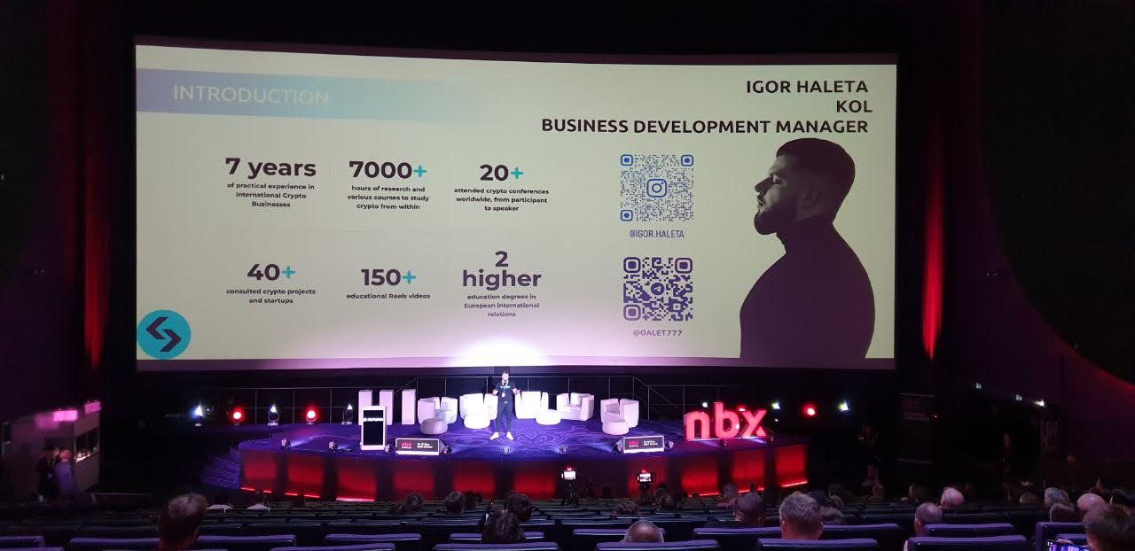 Igor Haleta speaking on the NBX main stage with track-record numbers behind him